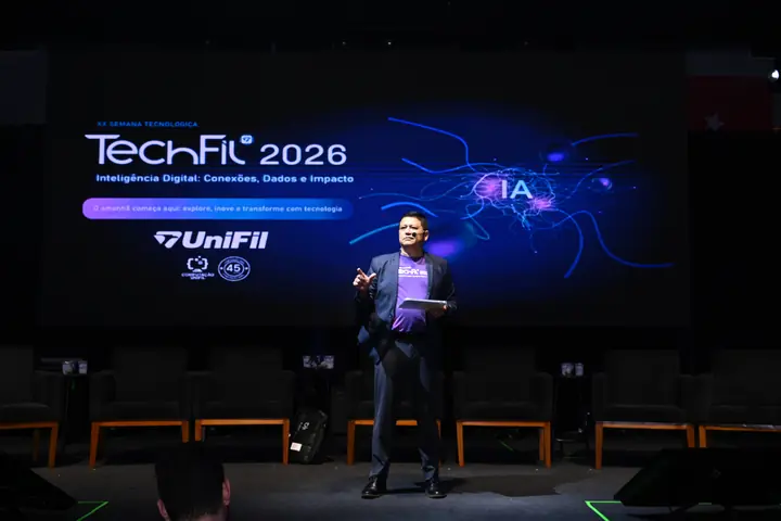 Apresentador fala ao público diante do telão da TechFil 2026