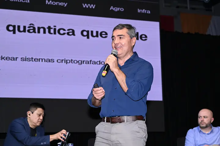 Palestrante fala sobre computação quântica e cibersegurança diante do telão