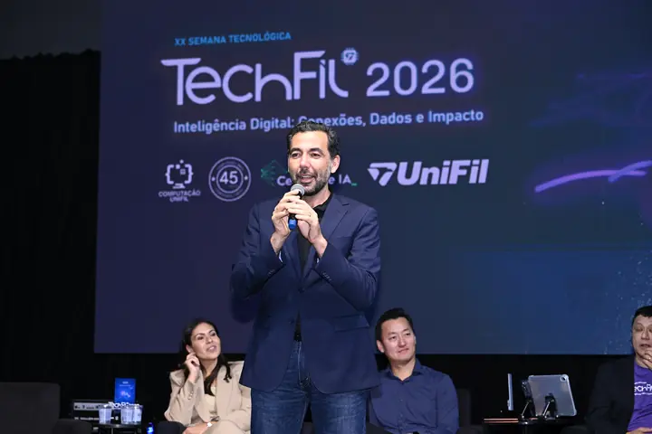 Convidado de terno fala ao microfone diante do telão da TechFil 2026