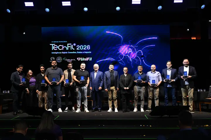 Debatedores da noite reunidos no palco com os troféus do evento