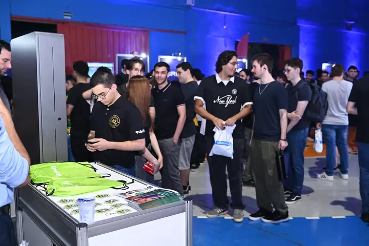 Participantes fazem fila em um estande com brindes