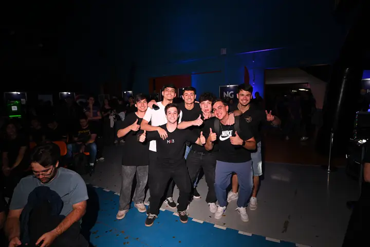 Grupo de estudantes posa com os polegares para cima no meio da plateia